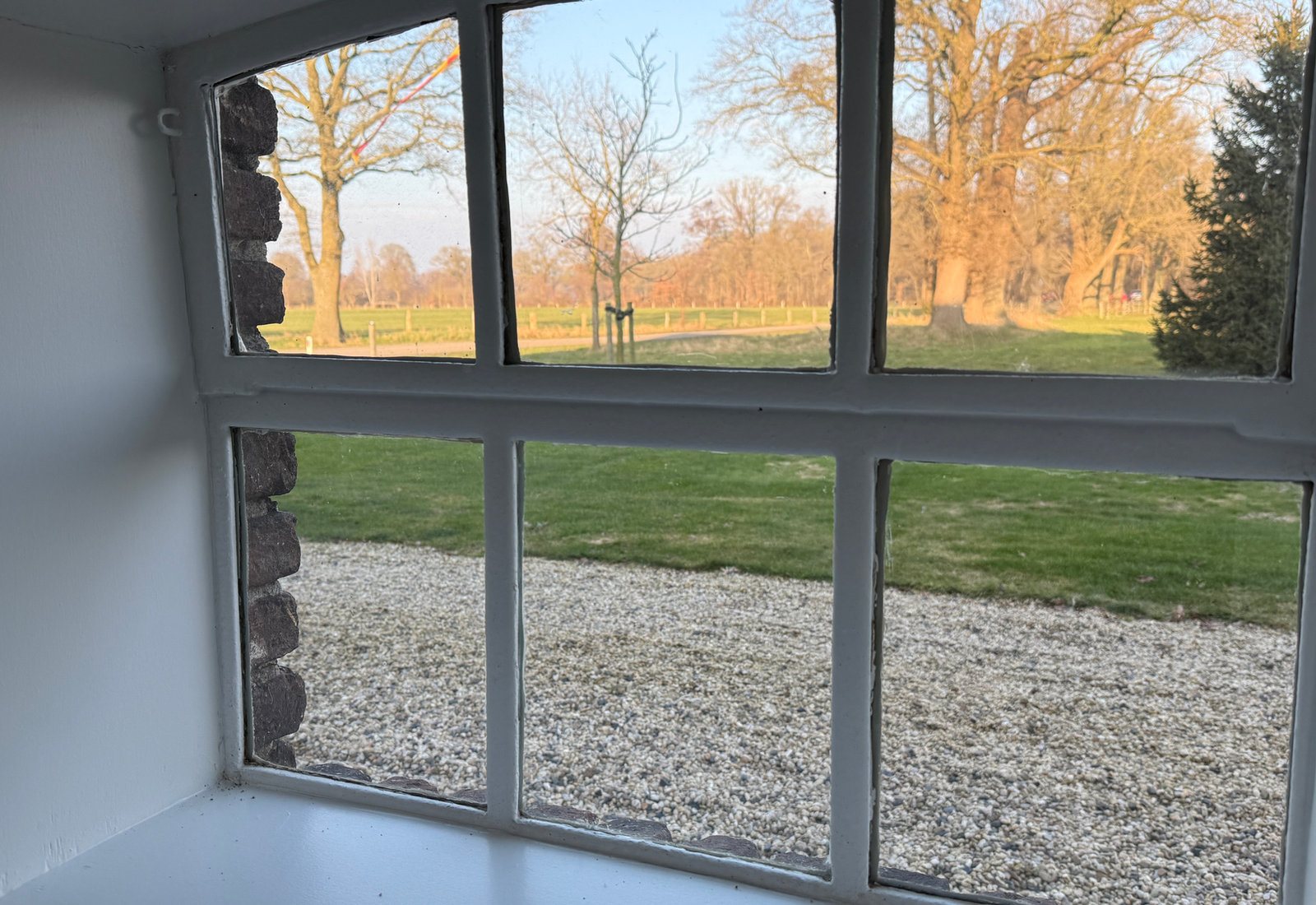 Uitzicht vanuit de hoeve door een oorspronkelijk raam